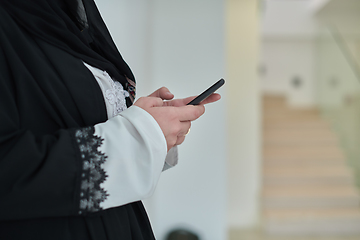 Image showing Portrait of Arab woman in traditional clothes using mobile phone.