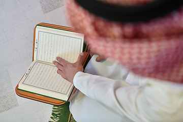 Image showing Young muslim man reading Quran during Ramadan