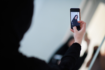 Image showing Young muslim businesswoman in traditional clothes or abaya taking selfie.