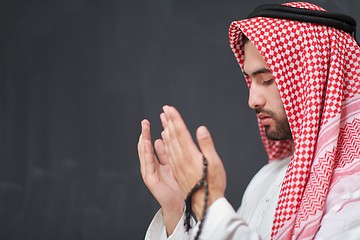 Image showing Arab man in traditional clothes praying to God or making dua