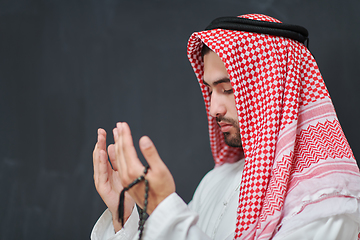 Image showing Arab man in traditional clothes praying to God or making dua