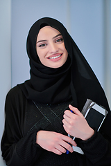 Image showing Young Arab businesswoman in traditional clothes or abaya with tablet computer