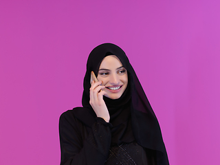 Image showing Young muslim businesswoman in traditional clothes or abaya using smartphone