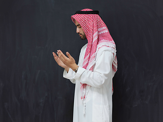 Image showing Arab man in traditional clothes praying to God or making dua