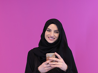 Image showing Young muslim businesswoman in traditional clothes or abaya using smartphone