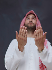 Image showing Arab man in traditional clothes praying to God or making dua