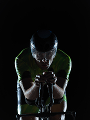 Image showing triathlon athlete riding bike on rainy night