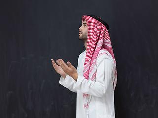 Image showing Arab man in traditional clothes praying to God or making dua