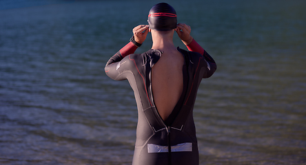 Image showing authentic triathlon athlete getting ready for swimming training on lake