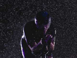 Image showing triathlon athlete riding bike on rainy night