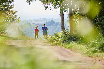 Image showing couple enjoying in a healthy lifestyle while jogging on a country road