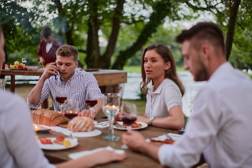 Image showing friends having picnic french dinner party outdoor during summer holiday