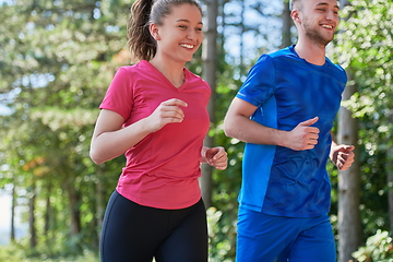 Image showing couple enjoying in a healthy lifestyle while jogging on a country road