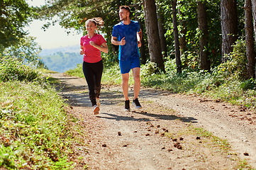 Image showing couple enjoying in a healthy lifestyle while jogging on a country road