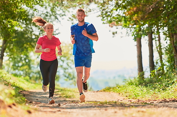 Image showing couple enjoying in a healthy lifestyle while jogging on a country road