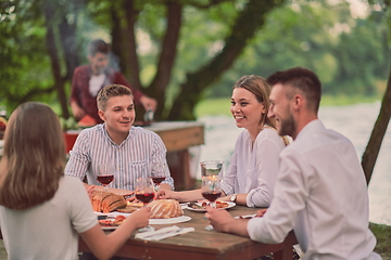 Image showing friends having picnic french dinner party outdoor during summer holiday