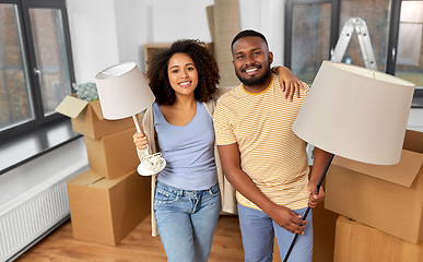 Image showing happy couple packing boxes and moving to new home