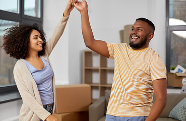 Image showing happy couple moving to new home and dancing