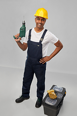 Image showing happy indian builder in helmet with electric drill