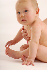 Image showing A naked baby looking around