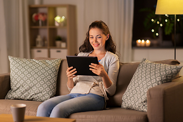 Image showing happy woman with tablet pc at home in evening