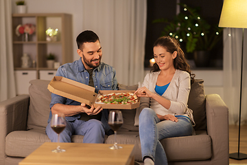 Image showing happy couple eating takeaway pizza at home