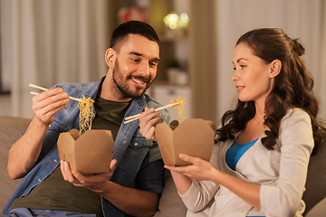 Image showing happy couple eating takeaway noodles at home