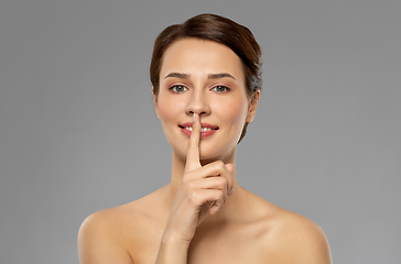 Image showing beautiful young woman holding finger on lips
