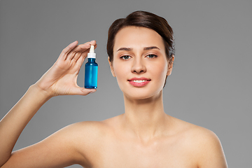 Image showing beautiful young woman with bottle of serum