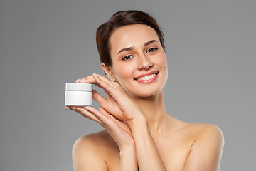 Image showing happy young woman holding jar of cream