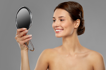 Image showing beautiful young woman looking to mirror