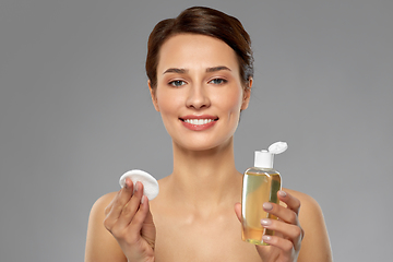 Image showing young woman with toner or cleanser and cotton pad