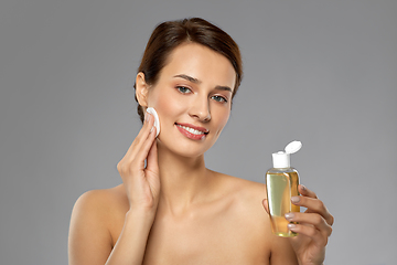 Image showing young woman with toner or cleanser and cotton pad