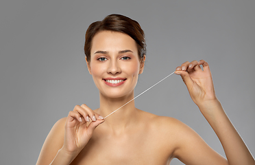 Image showing happy young woman with dental floss cleaning teeth