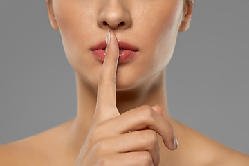 Image showing beautiful young woman holding finger on lips