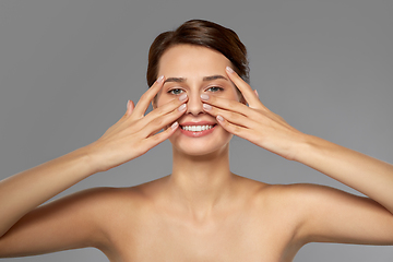 Image showing beautiful young woman touching her face