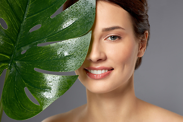 Image showing beautiful young woman with green monstera leaf