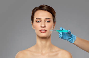 Image showing beautiful young woman and hand with syringe