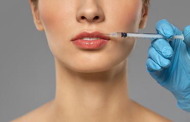 Image showing beautiful young woman and hand with syringe