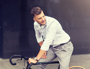 Image showing man with bicycle and headphones on city street