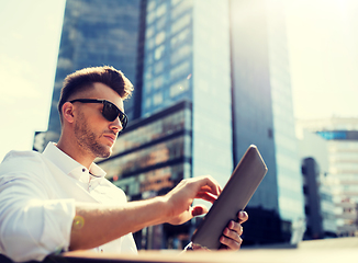 Image showing man with tablet pc sitting on city street bench