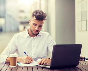 Image showing man with laptop and coffee at city cafe