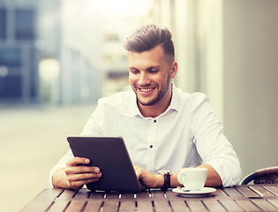 Image showing man with tablet pc and coffee at city cafe