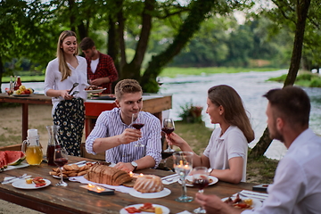 Image showing friends having picnic french dinner party outdoor during summer holiday