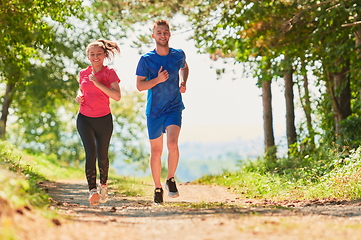 Image showing couple enjoying in a healthy lifestyle while jogging on a country road