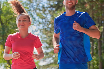 Image showing couple enjoying in a healthy lifestyle while jogging on a country road