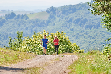 Image showing couple enjoying in a healthy lifestyle while jogging on a country road