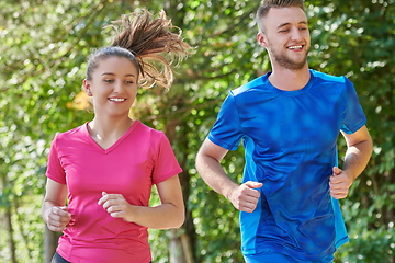 Image showing couple enjoying in a healthy lifestyle while jogging on a country road