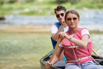 Image showing friends are canoeing in a wild river