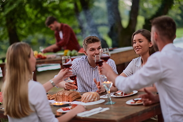 Image showing friends having picnic french dinner party outdoor during summer holiday